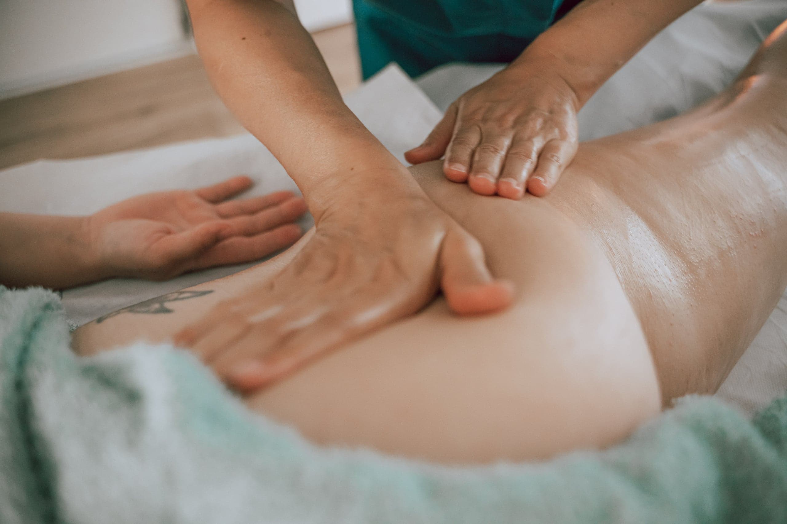 Pétrissage à deux mains sur la hanche d'une cliente lors d'un massage anticellulite, cabinet de Vertou près de Nantes